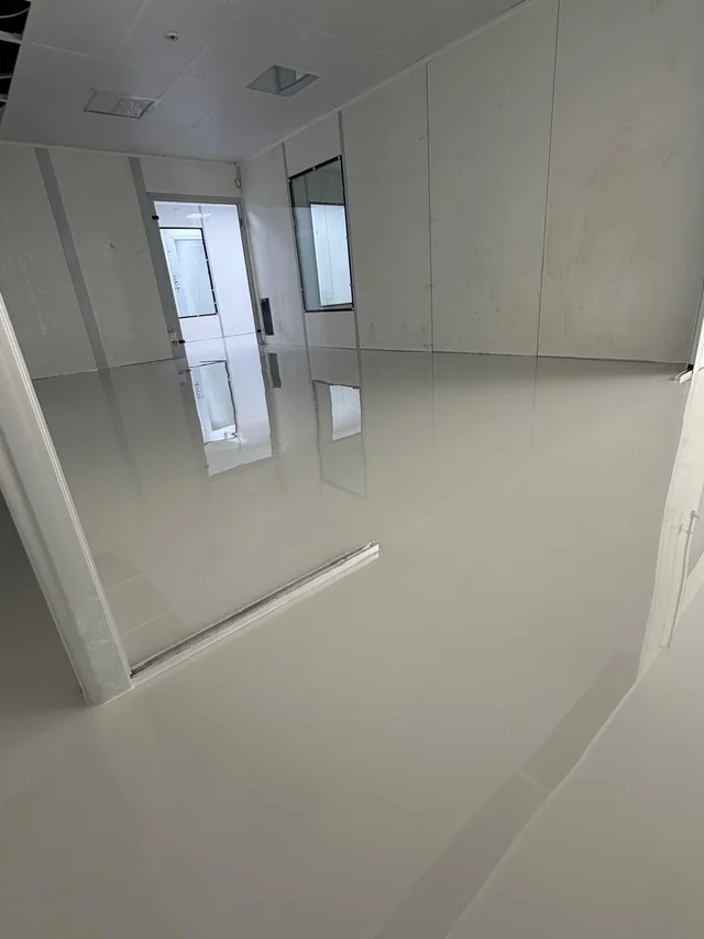 Aydınlık iç mekânda tamamlanmış gri self leveling epoksi zemin uygulaması